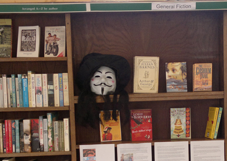 V for Vendetta mask among the books at the squatted library